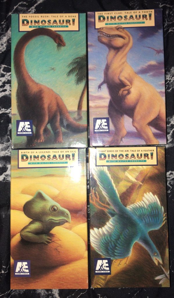 A selection of tapes of the documentary series "Dinosaur!" each depicting a different dinosaur; Brachiosaurus, Tyrannosaurus, Protoceratops, and Archaeopteryx.